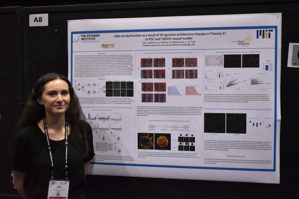 A woman stands with a research poster at a neuroscience conference