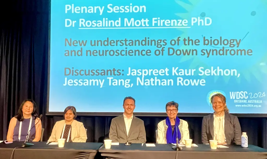 An image of the panel members, host and speaker seated at the discussion table on stage.